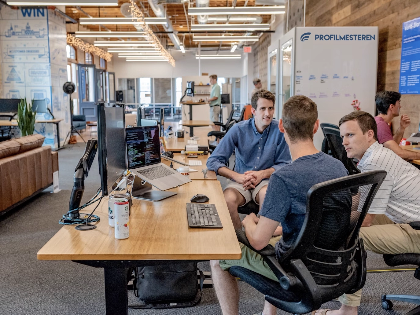 Modern office environment with Profilmesteren banner visible in background